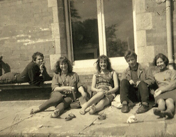 5 people, who are part of the Diploma in Art and Design Course, sit on the ground in front of Falmouth University in 1963.