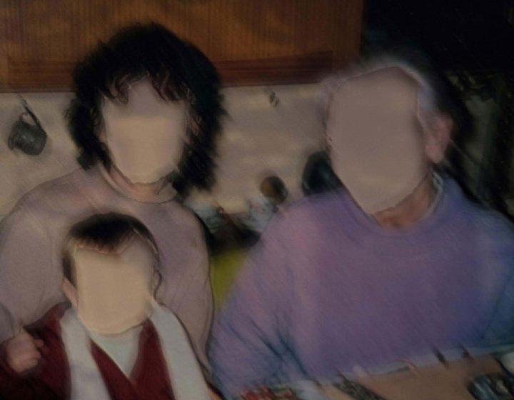 A blurred family portrait image with two adults and one child in
