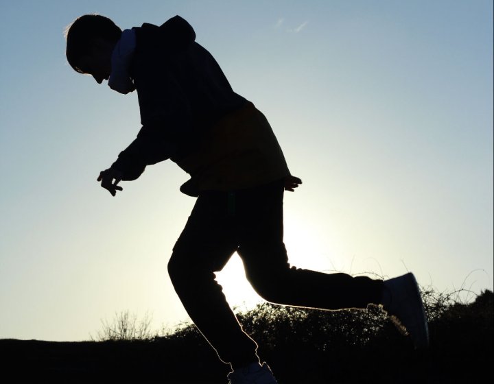 A silhouette of a person running outdoors