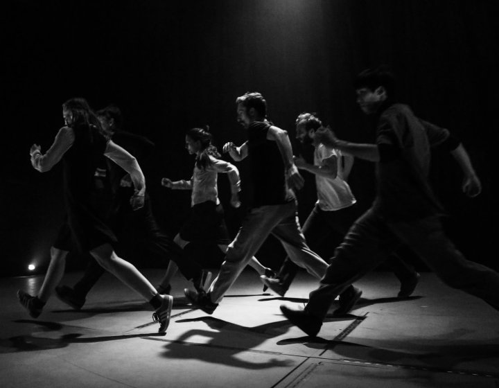 A black and white image of people dancing on stage