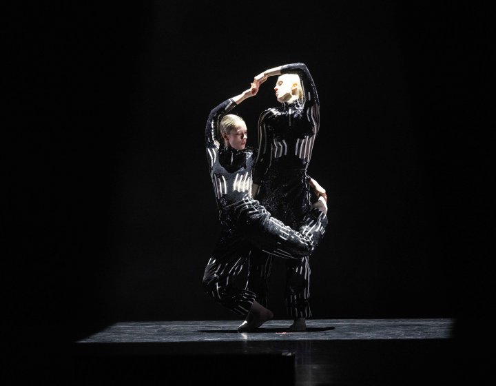 @ dancers dressed in black and silver performing on stage