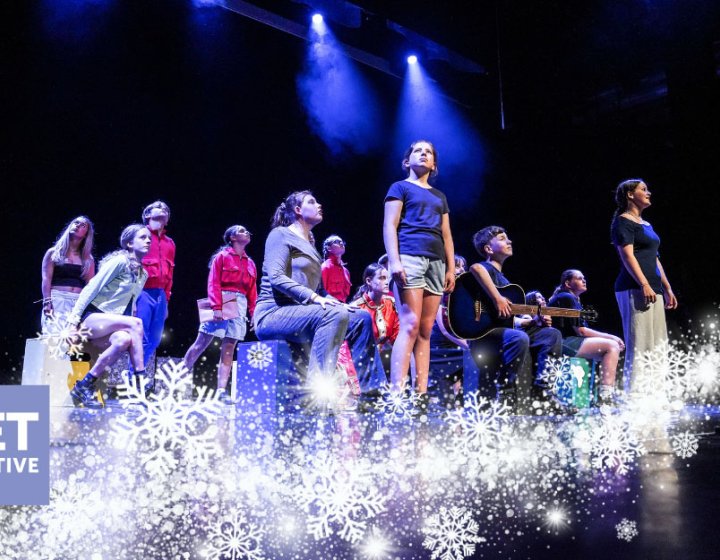 A group of young performers on the Hall for Cornwall Stage with a winter motif on the image