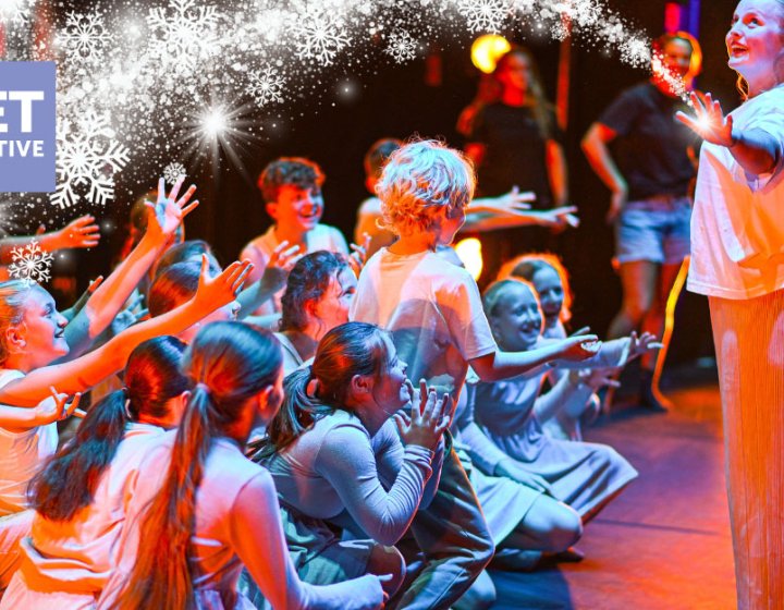 A group of young performers on the Hall for Cornwall Stage with a winter motif on the image