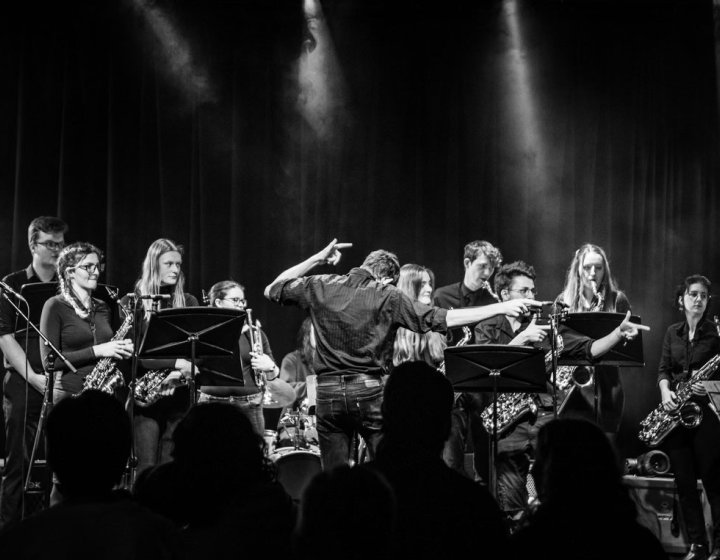Black and white image of a large big band ensemble performing on stage