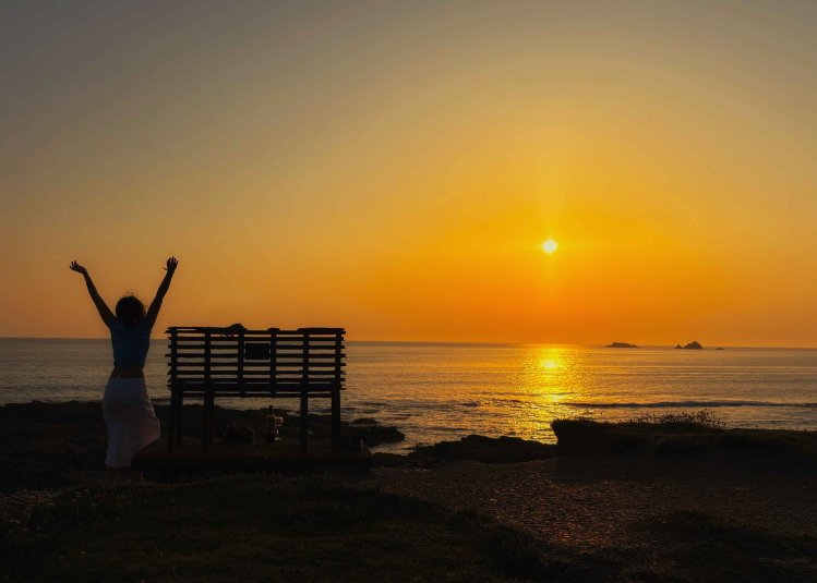 A sunny image with a person next to a bench