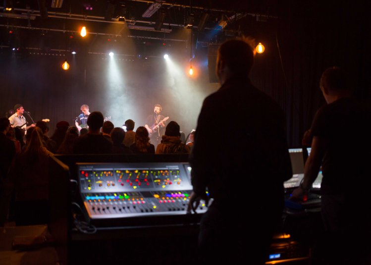 A silhouet image of a person mixing a live band in a gig studio
