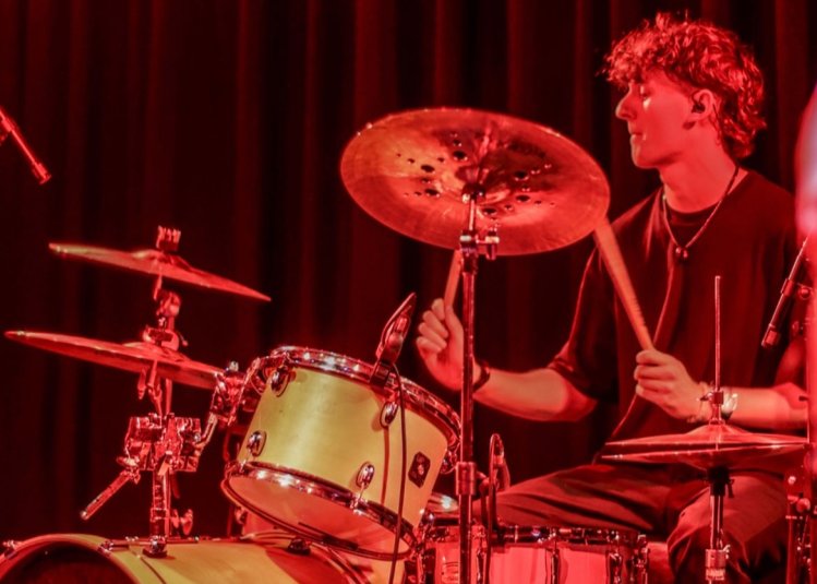 A person drumming under a orange red light