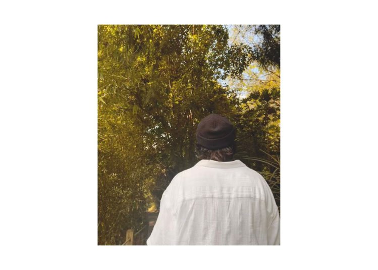 An outdoor image with a person in the centre looking away from the camera