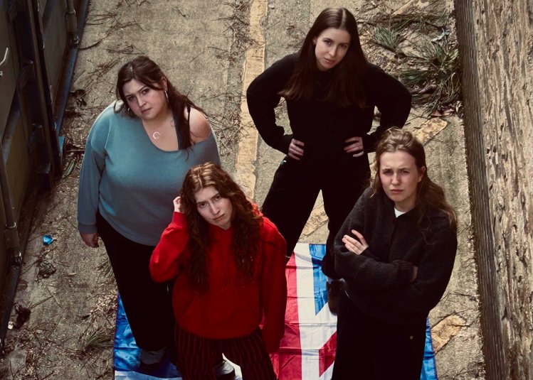 A group of 4 people with the Union Jack flag under them