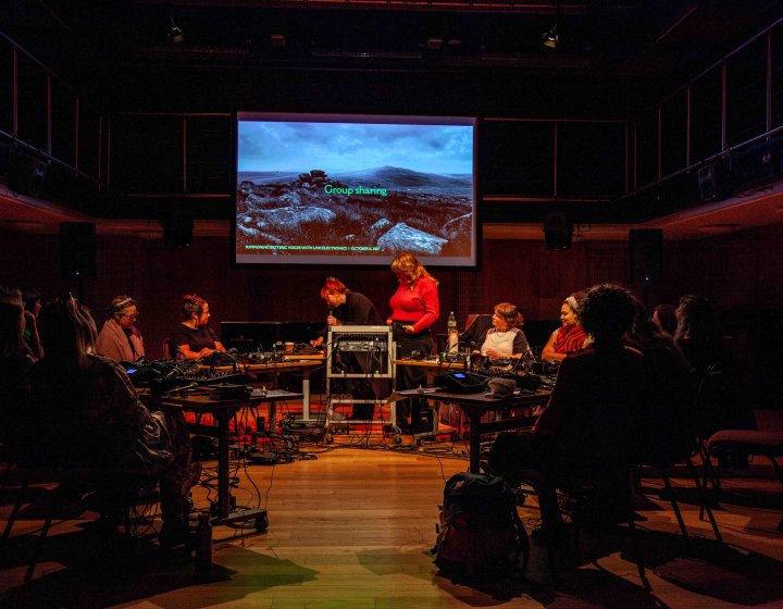 Gr group of musicians at various stations in a circle interacting and performing electronic music