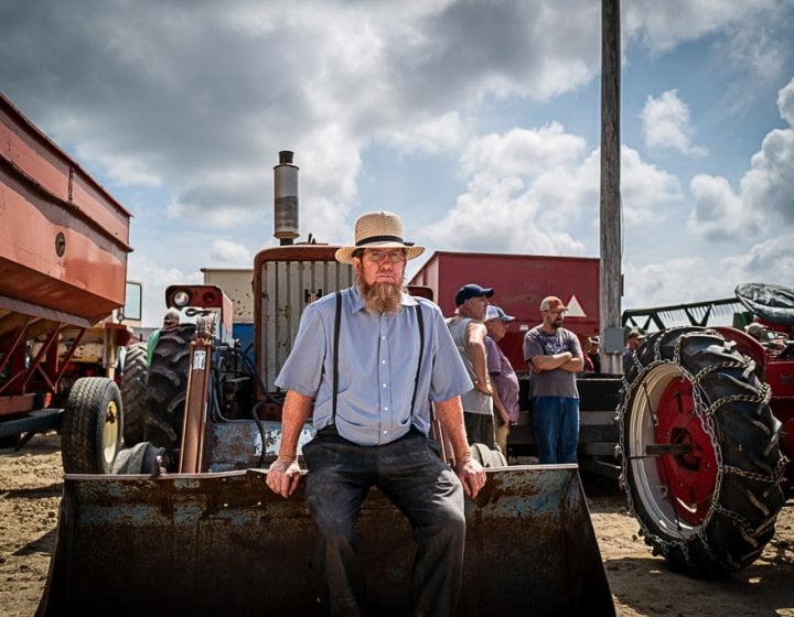 A man sitting on the front of a tractor