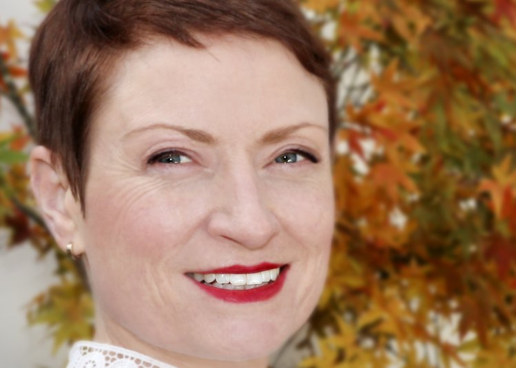 A woman with short hair smiling into the camera