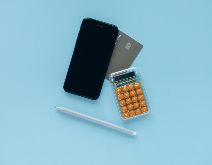 Phone, calculator and bank card on blue background
