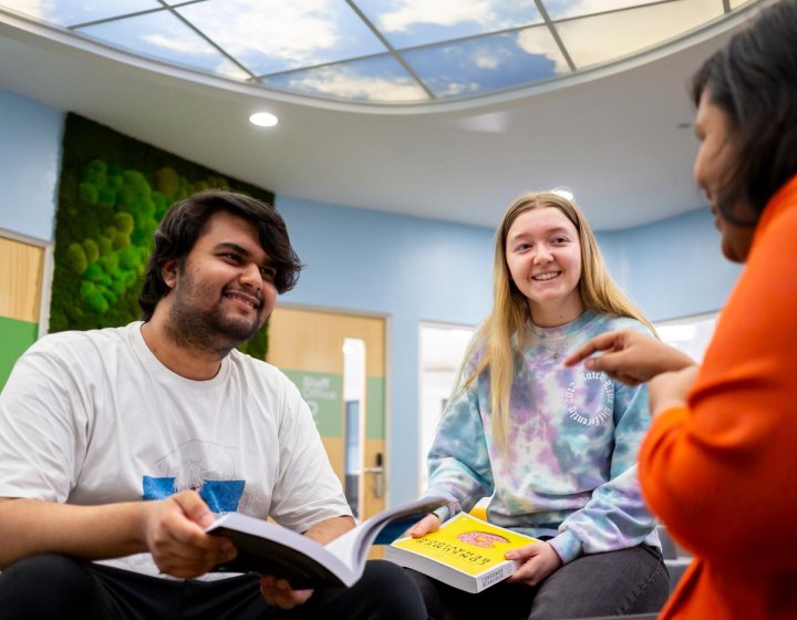 Three business students sat down, talking at Falmouth University