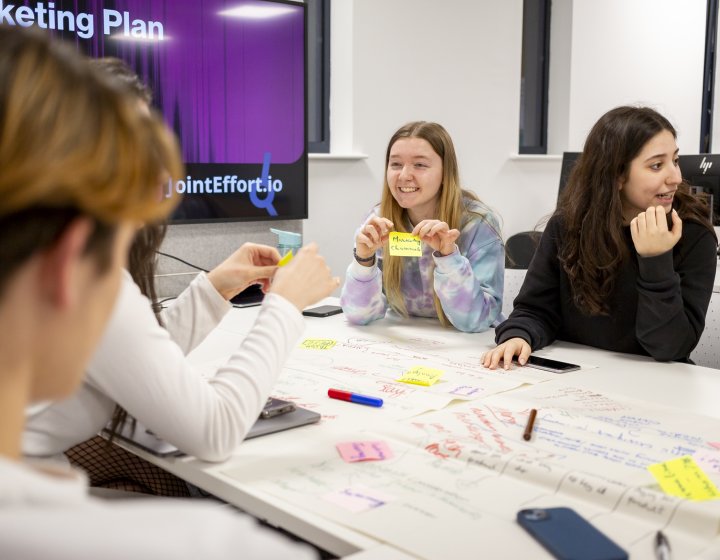 Group of students sat round a table mind mapping