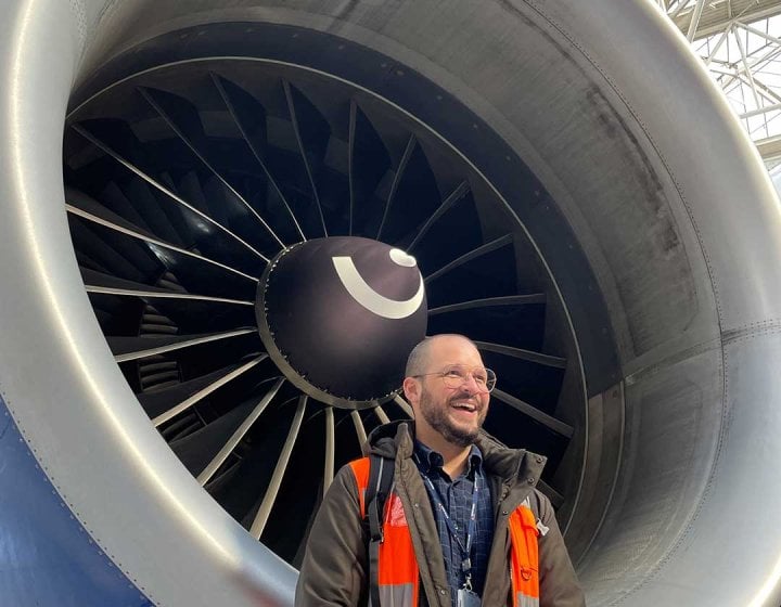 UX Design online tutor Cralos stood next to an airplane engine