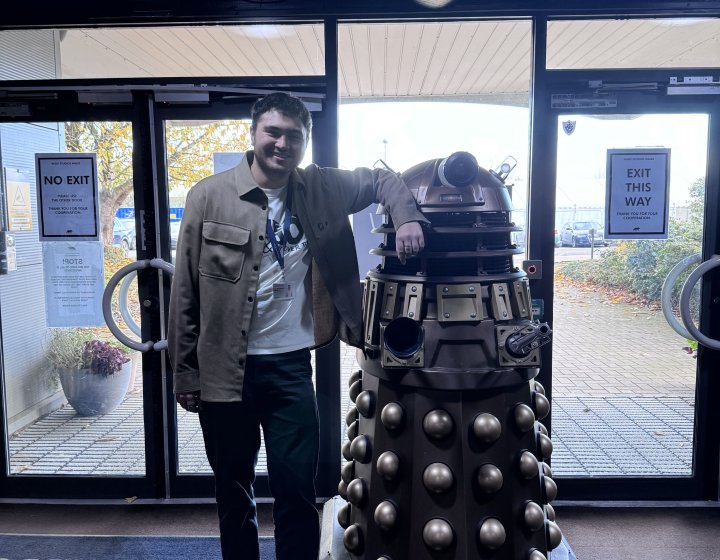 Television graduate Charles Jackson standing with Dalek in Doctor Who studios