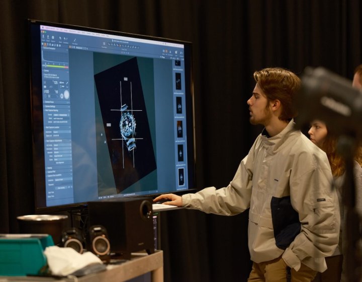 A Falmouth University Commercial Photography student editing a photograph of a watch on a large screen