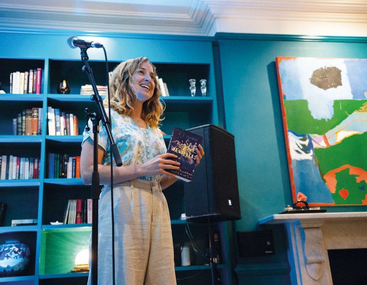 Student stood at microphone in front of bookcase