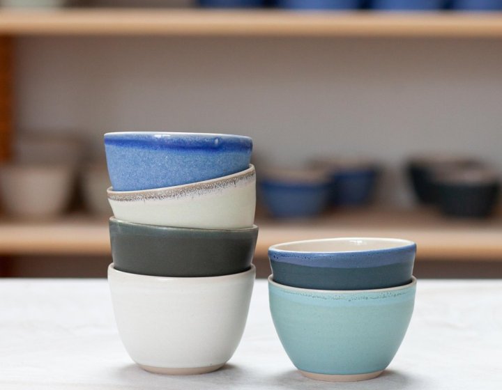 Two stacks of small ceramic bowls in white, blue and green hues.