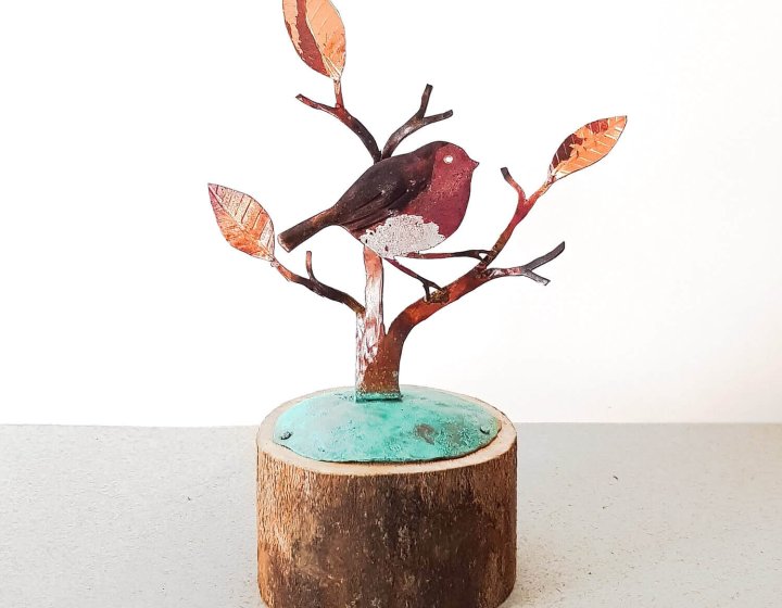 metal work of a robin perched on a branch