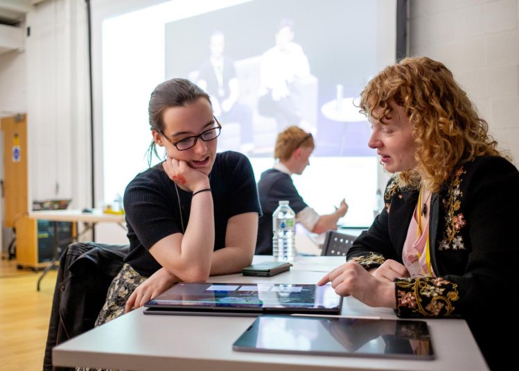 A student and industry person discussing work on a screen