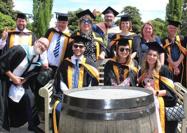 A group of Falmouth master's graduates sat together