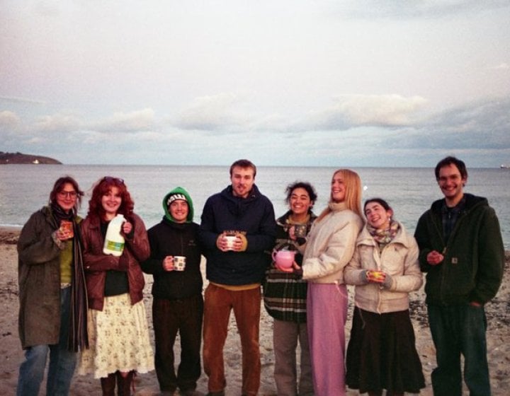 A group of first year Falmouth University student on the beach at dusk