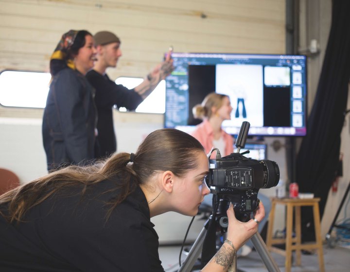 Fashion photography student taking photo in studio