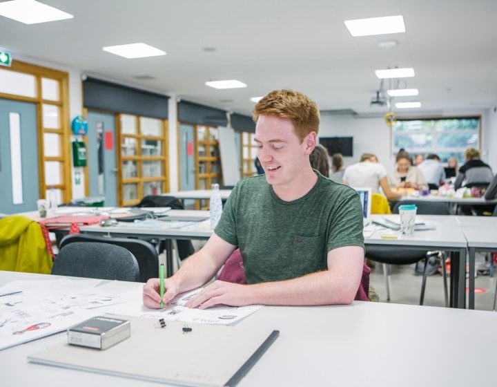 A male student in the Graphic Design studio at Falmouth University