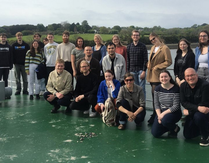 Graphic design staff, students and alumni project team photo on board a boat