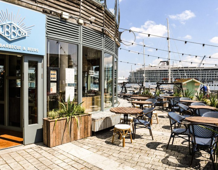 Hub Box restaurant exterior building with planters, tables and chairs