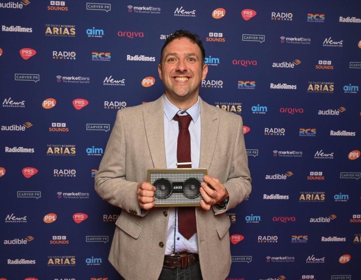 A man holding a radio award