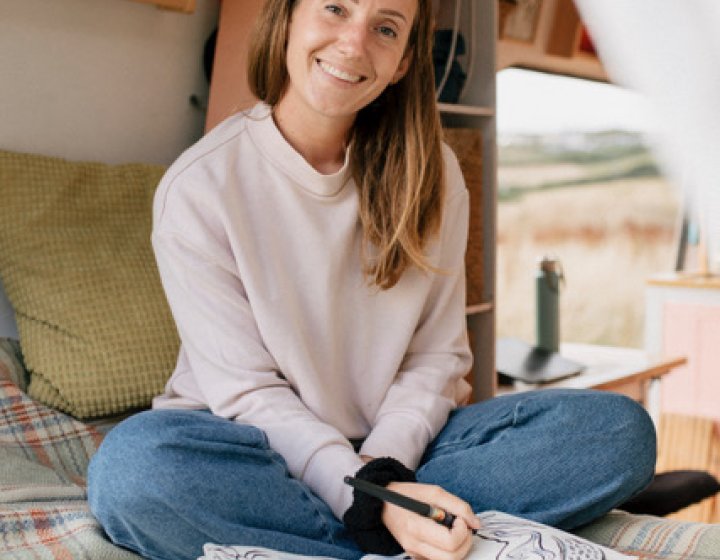 A woman sat in her van with her sketchbook