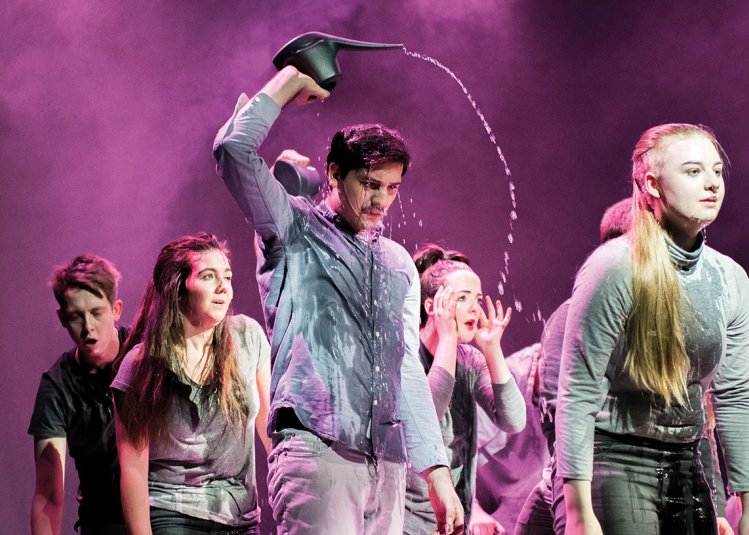 Theatre students on stage pouring water on head