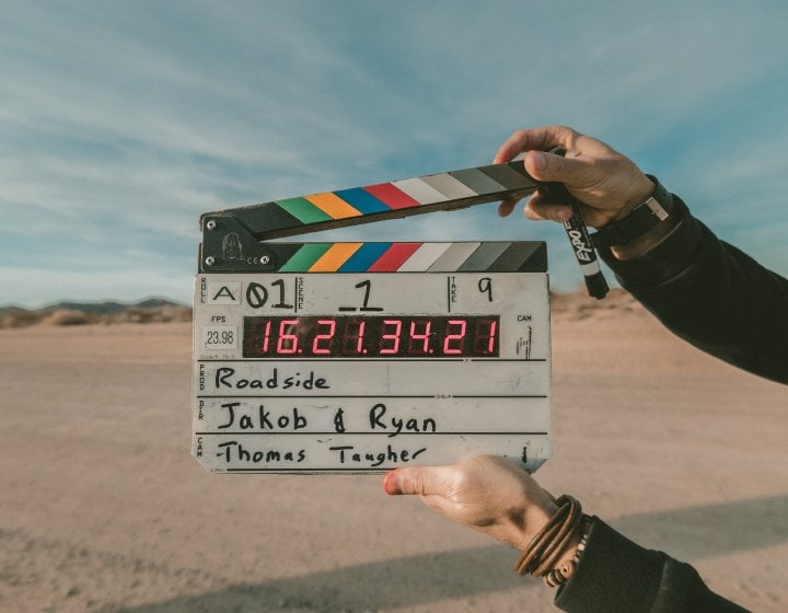 A film slate being held up against an empty field 