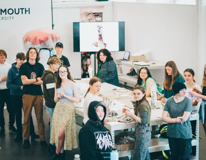 A group of young people making artworks on a large table