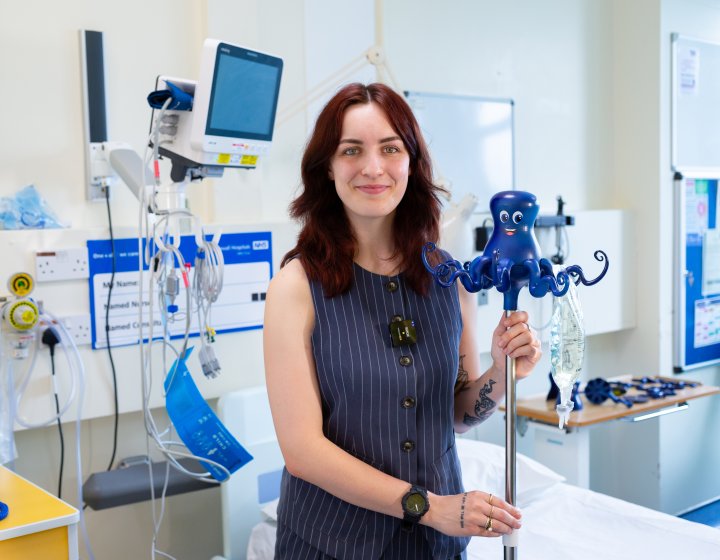 Image of person holding an IV drip holder in a hospital