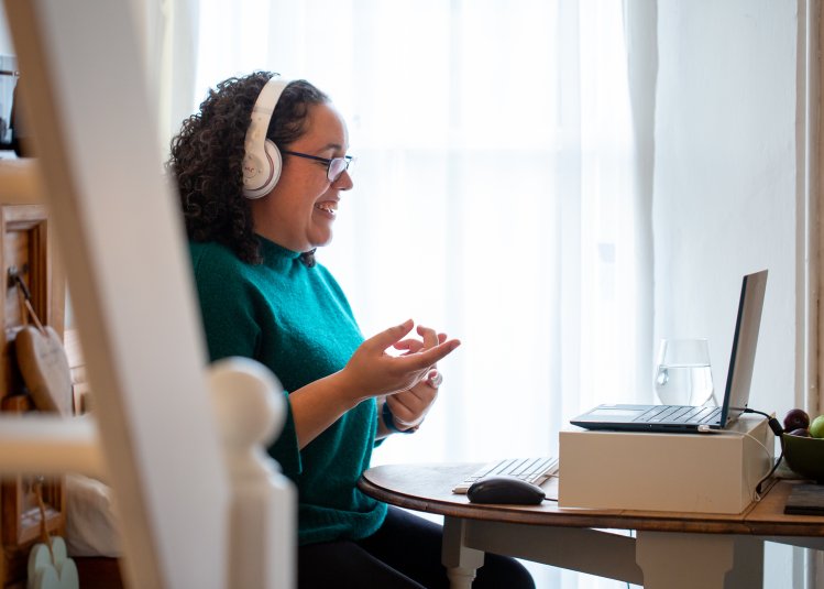 Woman sat at laptop laughing