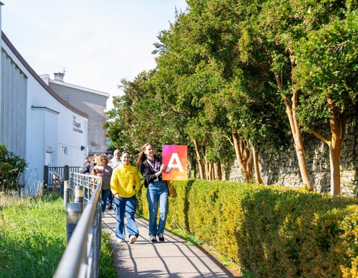 A group of people walking outside at a Falmouth University Open Day