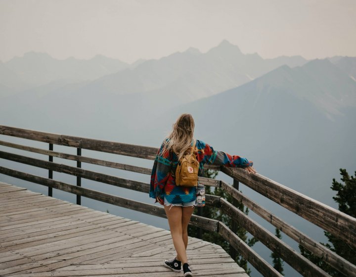 A young woman looks out at a mountain range