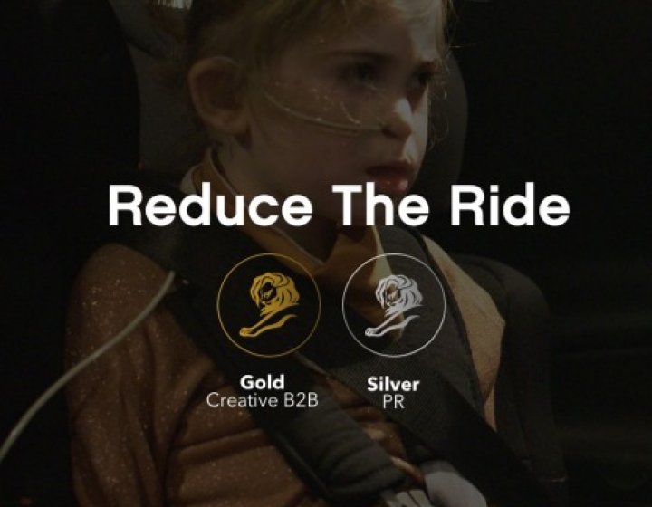 A child sits on a car seat, with the words 'Reduce The Ride' in the foreground