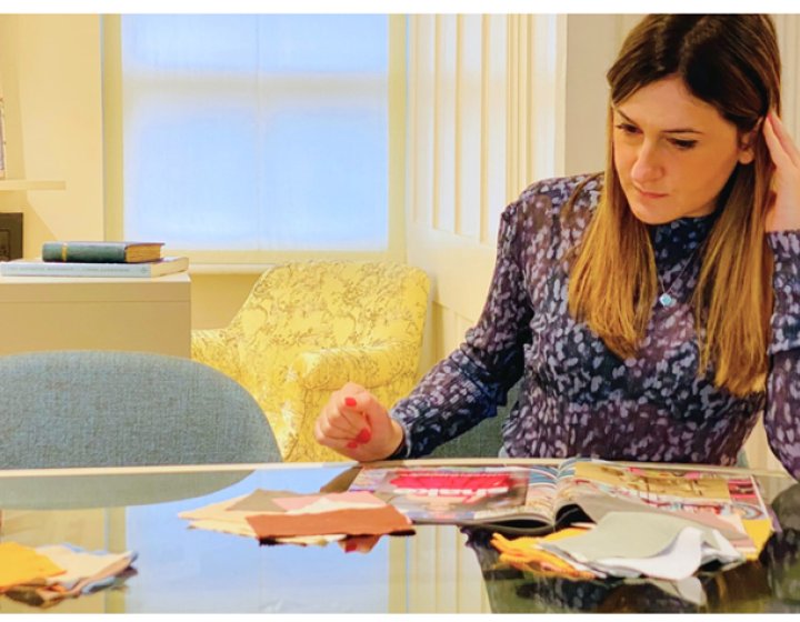 A woman sat at a desk drawing