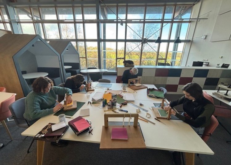 Group of people bookbinding at a table