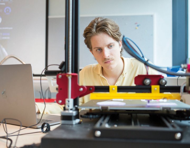 Student at desk working with robotic equipment