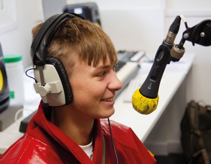 student smiling into microphone in studio