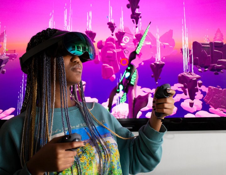 Falmouth University student wearing a VR headset in front of a pink screen