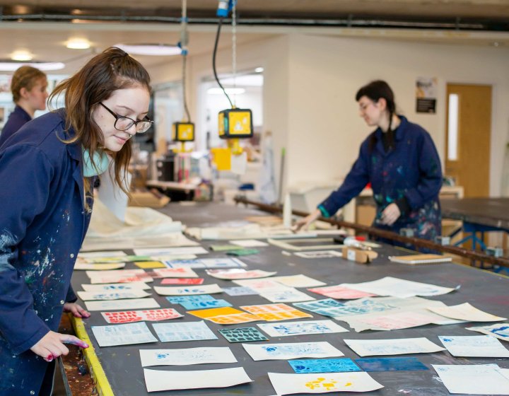 Photo of people working on textiles in a studio