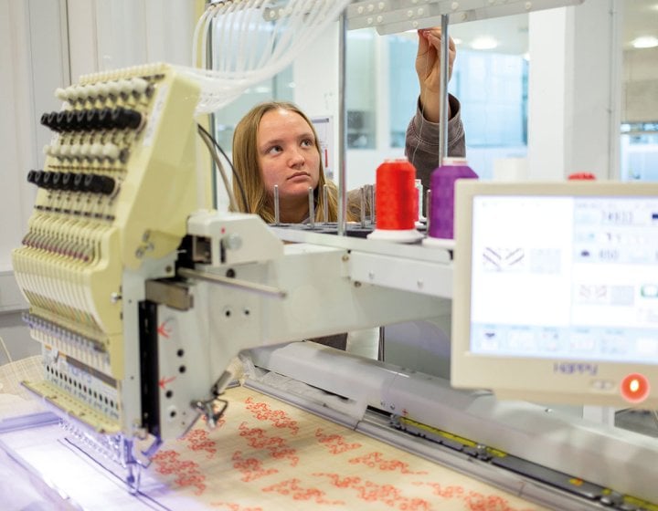 Textiles student working on machine