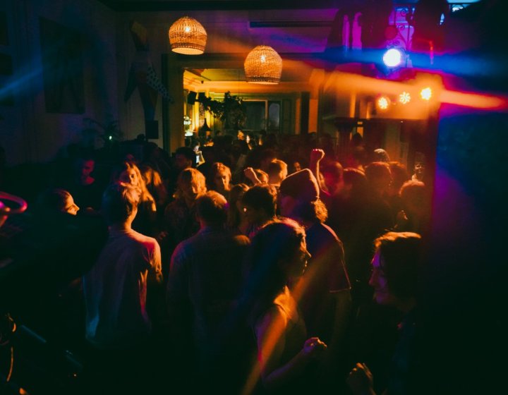 Dark photo of a crowd of people enjoying a live band.